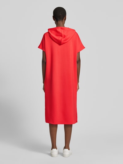 Männermodel trägt Sweatkleid mit Kapuze von Soyaconcept, mieszanka materiałów z domieszką modalu, prosty krój, sukienka midi, kaptur, nadruk z logo, widok całej sylwetki z tyłu.