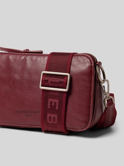 Produktfoto, bordeauxrote Handtasche mit Label-Detail Modell 'CLARICE' von LIEBESKIND BERLIN, strukturierte Lederoptik, Reißverschluss, breiter Schulterriemen mit Markenprägung, Maße und Details laut Kontext
