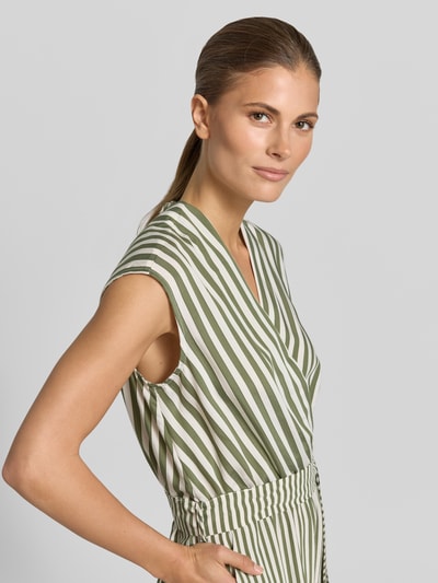 Frauenmodel trägt Jumpsuit aus Viskose-Mix mit V-Ausschnitt von Rinascimento, Streifenmuster in Grün und Weiß, taillierte Passform, Nahaufnahme Oberkörper