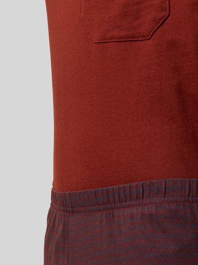 Männermodel trägt Pyjama in minimalistischem Design von Schiesser aus Reine Baumwolle mit Brusttasche und V-Ausschnitt, Nahaufnahme Oberkörper.