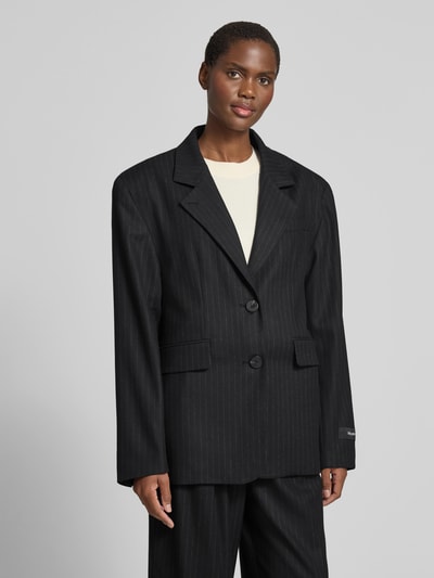 Frauenmodel trägt Relaxed Fit Blazer mit Viskose-Anteil von black palms in Schwarz mit feiner Streifenstruktur, Reverskragen, 2-Knopf-Leiste, Logo-Patch, Ganzkörperansicht von vorne, Elastischer-Material-Mix, Rückenlänge 76 cm, Brustweite 60 cm, Ärmellänge 66 cm