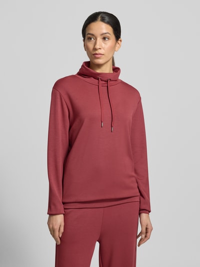 Frauenmodel trägt Sweatshirt mit Tunnelzug Modell 'Banu' von Soyaconcept, lockerer Schnitt, Stehkragen, rot, Ganzkörperansicht von vorne.