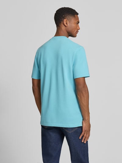 Männermodel trägt Regular Fit Poloshirt aus Baumwoll-Mix von s.Oliver RED LABEL in Hellblau, Piqué-Struktur, Rückansicht Ganzkörperansicht.