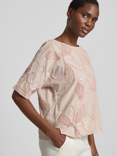 Frauenmodel trägt Blusenshirt aus reiner Baumwolle von Christian Berg Woman, Damen Kurzarmbluse im Regular-Fit, Allover-Look mit Stitchings, Rundhalsausschnitt, Rosa- und Cremetöne mit strukturierter Oberfläche, Rückenlänge bei Größe 36: 55 cm, Ärmellänge bei Größe 36: 29 cm, Ganzkörperansicht von vorne.