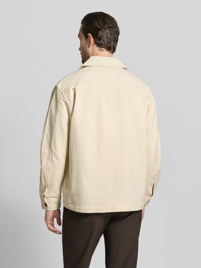 Männermodel trägt Relaxed Fit Freizeithemd aus reiner Baumwolle Modell 'RLXRAY' von SELECTED HOMME, beige, strukturiert, Ganzkörperansicht Rückansicht.