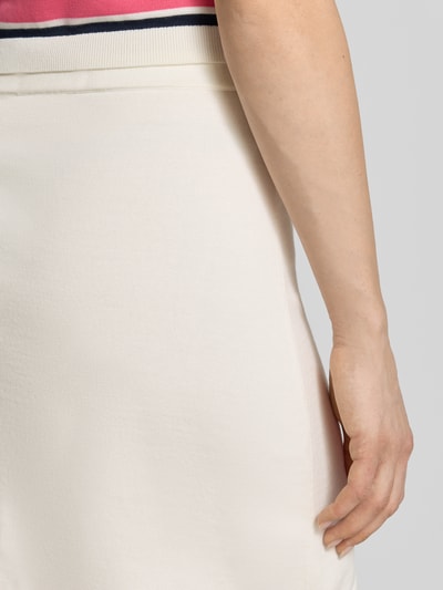 Kobiece modelka nosi eng anliegender Mini-Rock aus reiner Baumwolle Modell 'AMOUR' von Selected Femme, kremowy, dzianina, krój regular fit, mini, elastyczny pas, prosty dół, widok z tyłu, zbliżenie na biodra.