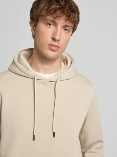 Männermodel trägt Hoodie mit Kapuze Modell 'BRADLEY' von Jack & Jones, lockerer Schnitt, Material-Mix, Nahaufnahme Oberkörper.