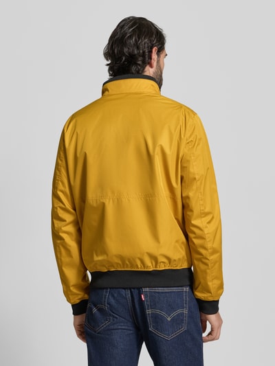 Männermodel trägt Regular Fit Jacke mit Stehkragen von MCNEAL, gelb, elastische Abschlüsse, Rückenlänge 64 cm, Ganzkörperansicht Rückansicht.