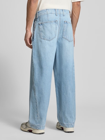 Männermodel trägt Barrel Fit Jeans mit Falten von Calvin Klein Jeans in Hellblau, reine Baumwolle, Ganzkörperansicht Rückansicht.