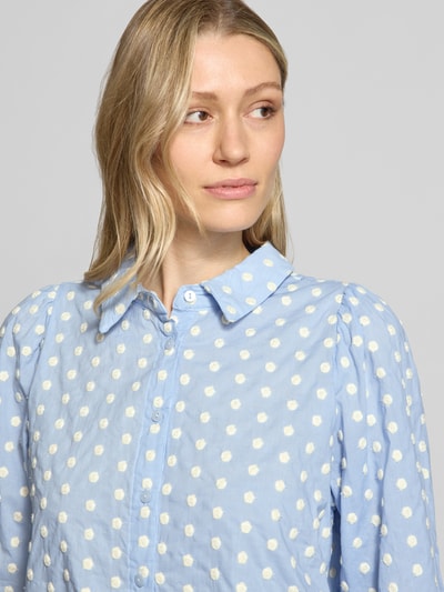 Frauenmodel trägt Regular Fit Bluse im Allover-Look Modell 'Bono' von LOLLYS LAUNDRY aus reiner Baumwolle, Hemdblusenkragen, Knopfleiste, 3/4-Arm, Rückenlänge 60 cm bei Größe S, Ärmellänge 38 cm bei Größe S, hellblau mit weißen Tupfen, strukturierte Oberfläche, Nahaufnahme Oberkörper.