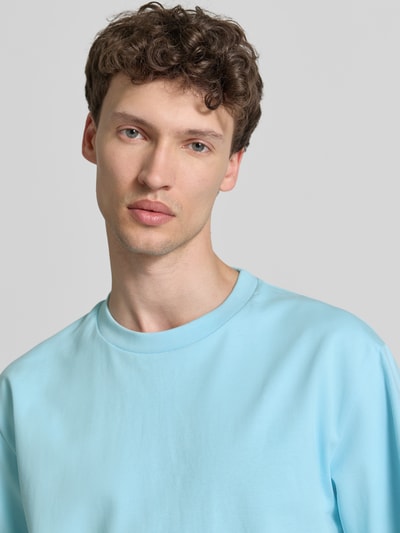 Männermodel trägt Oversized T-Shirt mit Rundhalsausschnitt von Lindbergh in Hellblau aus Reine Baumwolle, Nahaufnahme Oberkörper.
