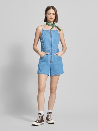 Kobiece model nosi Regular Fit Playsuit aus Denim od Levi's®, jasnoniebieski dżins, kontrastowe szwy, pasek w talii, szelki, kieszenie, krój regular fit, bawełna, widok całej sylwetki z przodu.