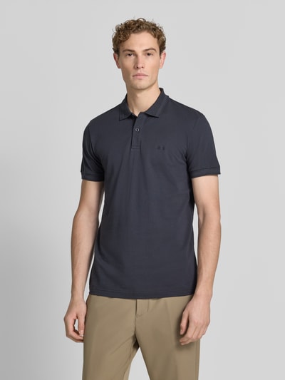 Męski model nosi koszulkę polo Regular Fit Poloshirt aus reiner Baumwolle model 'PIO 1' od BOSS Green w kolorze ciemnoszarym, gładka faktura, widok całej sylwetki od przodu.