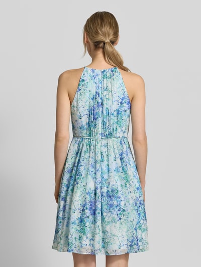 Frauenmodel trägt Minikleid in Falten-Optik mit floralem Allover-Print von Jake*s Cocktail, taillierte Passform, abnehmbares Stoffband, ärmelloses Design, Farbmix aus Blau, Türkis und Weiß, fließende Textur, Rückenlänge bei Größe 36: 87 cm, Brustweite: 35 cm, Ganzkörperansicht Rückansicht.
