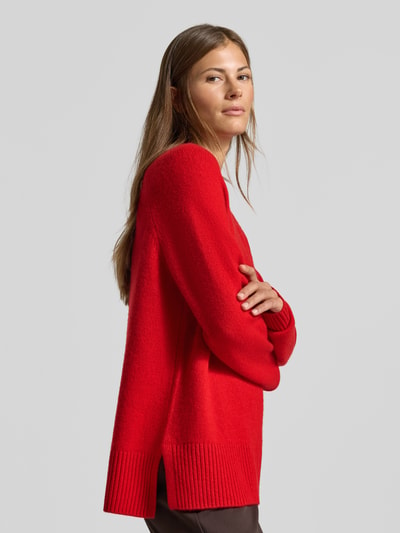 Frauenmodel trägt Regular Fit Pullover aus reinem Kaschmir in Strick-Optik von MYON, leuchtend rot, Rundhalsausschnitt, Seitenansicht, Nahaufnahme Oberkörper.