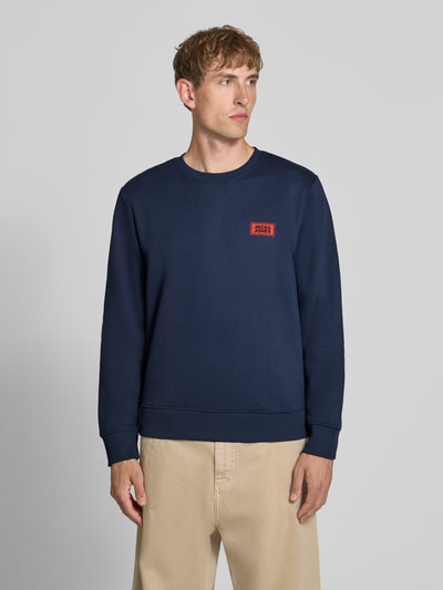Männermodel trägt donkerblauw Sweatshirt met labelprint Model 'RUSH' van JACK & JONES, katoenmix, los model, ronde hals, ribboorden, ruglengte maat M 67 cm, mouwlengte maat M 67 cm, voorkant, halfbody-opname