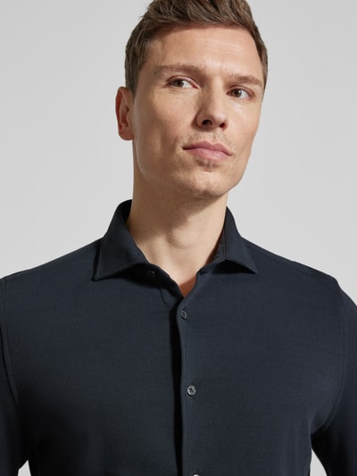 Männermodel trägt Shaped Fit Freizeithemd aus reiner Baumwolle von Marc O'Polo, unifarben, strukturierte Oberfläche, Nahaufnahme Oberkörper.