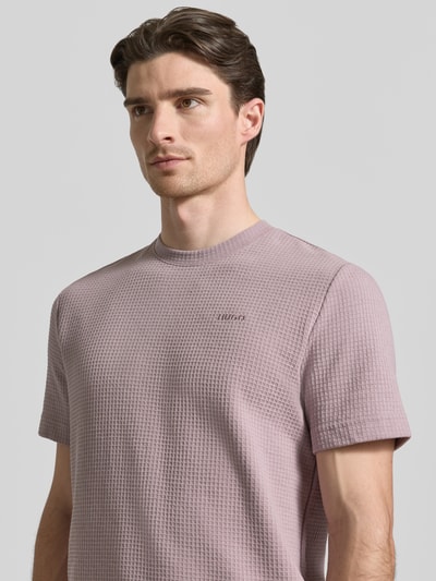 Männermodel trägt Regular Fit T-Shirt aus Baumwoll-Mix Modell 'AUSTIN' von HUGO, Optik: Unifarben, Waffelstruktur, Label-Stitching-Applikation, Rundhals, Kurzarm, Nahaufnahme Oberkörper.