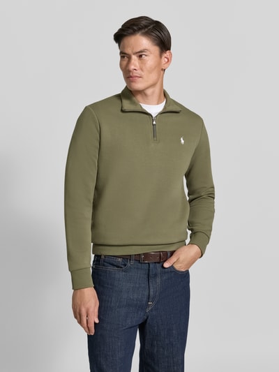 Męski model nosi Regular Fit Troyer aus Baumwoll-Mix od Polo Ralph Lauren, kolor oliwkowy, gładka tekstura, widok całej sylwetki z przodu.