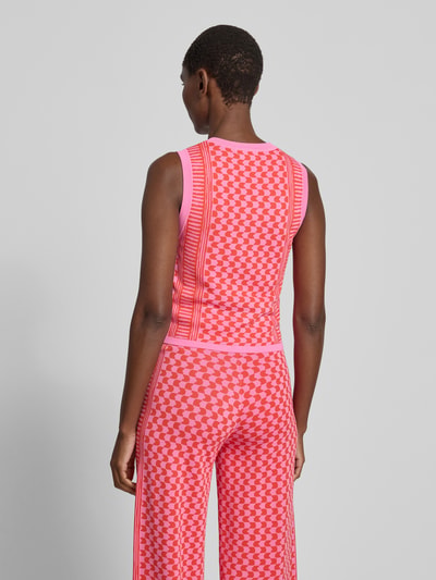 Frauenmodel trägt Strickweste aus Viskose-Mix Modell 'GABLESI' von SUNCOO PARIS in Pink- und Rottönen, körpernah, Ganzkörperansicht Rückansicht.