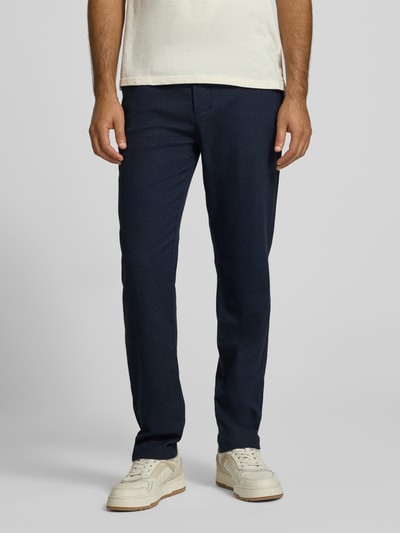 Männermodel trägt Hose aus Baumwoll-Woll-Mix mit Gesäßtaschen Modell 'STUART' von Scotch & Soda, dunkelblau, Slim Fit, Ganzkörperansicht von vorne, Bundweite 45 cm, Innenbeinlänge 80 cm.