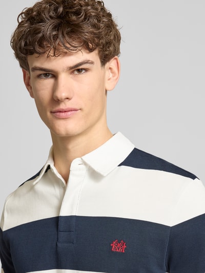 Männermodel trägt Regular Fit Poloshirt mit Rugby-Streifen und Logo-Bestickung von REVIEW, reine Baumwolle, Nahaufnahme Oberkörper.