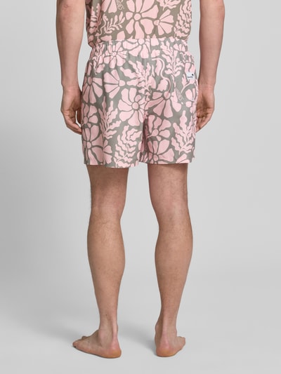 Männermodel trägt Badehose im Allover-Look Modell 'Melo' von BOARDIES mit elastischem Bund und Kordelzug, Ganzkörperansicht Rückansicht.