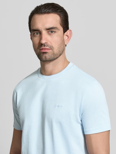 Männermodel trägt T-Shirt mit Rundhalsausschnitt und Label-Stitching von Gant aus reiner Baumwolle, Regular-Fit, Nahaufnahme Oberkörper.