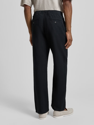 Męski model nosi Loose Fit Leinenhose mit Tunnelzug Modell 'BRODY' von Selected Homme, efekt: jednolity kolor, krój loose fit, szlufki na pasek, tunel, zapięcie na guzik i zamek błyskawiczny, wpuszczane kieszenie, kieszeń z tyłu z guzikiem, wykończenie materiału: cieniowana przędza, mieszanka bawełny ekologicznej i lnu, całkowity widok z tyłu