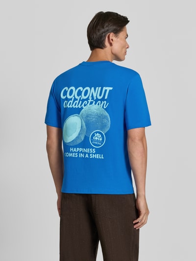 Männermodel trägt Relaxed Fit T-Shirt aus reiner Baumwolle von REVIEW, blau mit Motiv-Print, Rückenansicht, Nahaufnahme Oberkörper.