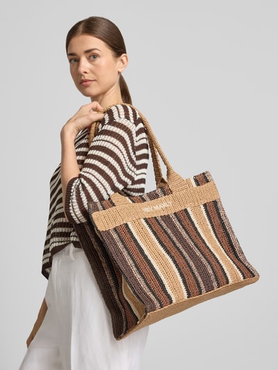 Frauenmodel trägt Strandtasche mit Logo-Stitching Modell 'Beach Bestie' von Hey Marly, gestreift in Braun, Beige, Offenes Hauptfach, kurze Tragegriffe, Reißverschlussfach innen, Breite 41 cm, Länge 32 cm, Tiefe 17 cm, Länge Schulterriemen 63 cm, Ganzkörperansicht von vorne.