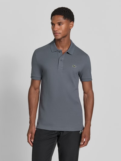 Männermodel trägt Slim Fit Poloshirt aus reiner Baumwolle von Lacoste, grau, dezente Struktur, Ganzkörperansicht von vorne, Herren Poloshirt