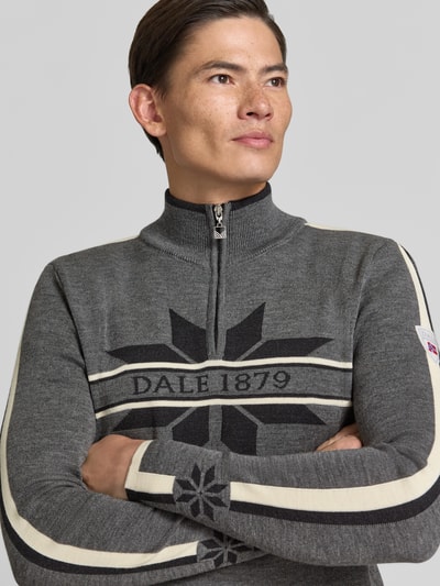 Männermodel trägt Wollpullover mit Label-Print Modell 'Nale' von Dale of Norway, reine Wolle, Troyer-Kragen, Nahaufnahme Oberkörper.