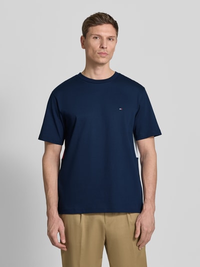Männermodel trägt Relaxed Fit T-Shirt aus reiner Baumwolle von Tommy Hilfiger in Dunkelblau mit Logo-Stitching, Ganzkörperansicht von vorne.