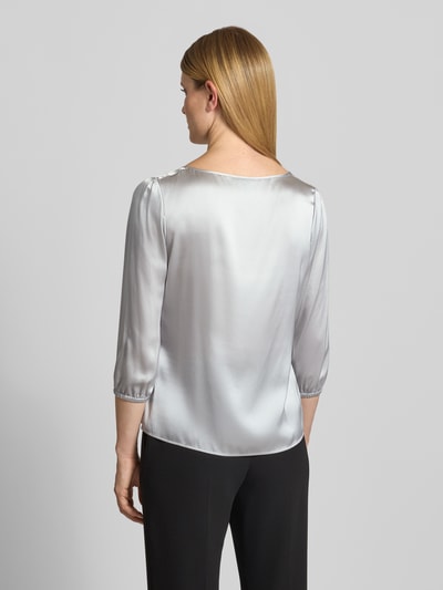 Modelka nosi Blusenshirt aus Seide mit 3/4-Arm von Marc Cain w odcieniu srebrzystoszarym, krój regular fit, okrągły dekolt, rękaw o dł. 3/4, długość tyłu w rozmiarze 36: 60 cm, długość rękawów w rozmiarze 36: 49 cm, gładka struktura, widok całej sylwetki z tyłu.