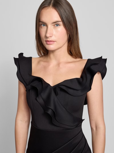 Frauenmodel trägt Abendkleid mit Volants von Lipsy in Schwarz, Material-Mix mit Stretch, Square-Neck, tailliert, Nahaufnahme Oberkörper.