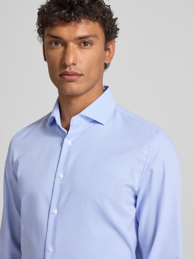Männermodel trägt Slim Fit Business Hemd aus Baumwolle mit Kentkragen von SEIDENSTICKER, hellblau, feine Textur, Knopfleiste, Nahaufnahme Oberkörper, Rückenlänge 79 cm, Schulterbreite 42 cm, Ärmellänge 67 cm bei Größe 40.