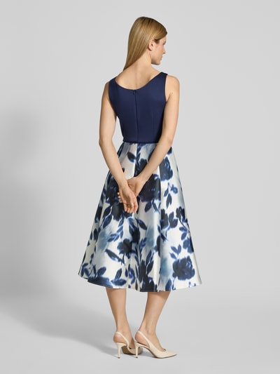 Frauenmodel trägt Cocktailkleid mit Rundhalsausschnitt von SWING, Satin, A-Linie, Midikleid, rückseitiger Reißverschluss, florales Muster, Ganzkörperansicht Rückansicht.