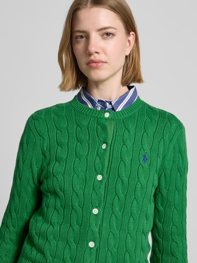 Frauenmodel trägt Regular Fit Strickjacke aus reiner Baumwolle von Polo Ralph Lauren in Optik: Unifarben, Strukturiert, Logo-Stitching, Zopfstrick, Knopfleiste, Rundhals, Langarm, Ärmelabschluss: Gerippt, Material: Reine Baumwolle, Nahaufnahme Oberkörper.