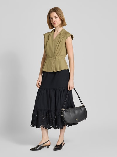 Frauenmodel trägt schwarzen Midirock mit Lochstitching von Christian Berg Woman Selection aus reiner Baumwolle, leichte A-Linie, Ganzkörperansicht von vorne.
