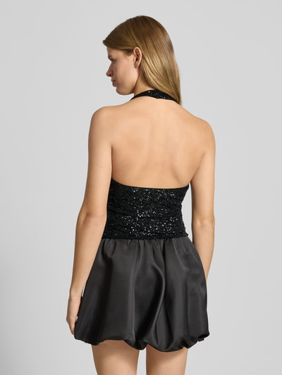 Frauenmodel trägt Tanktop mit V-Ausschnitt von Gina Tricot in Schwarz mit Paillettenbesatz, Slim-Fit, Neckholder, Rückenlänge 60 cm, Ganzkörperansicht Rückansicht.