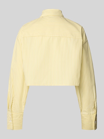 Frauenmodel trägt Regular Fit Pyjama-Oberteil aus reiner Baumwolle von Calvin Klein Underwear mit gelbem Allover-Streifenmuster und Hemdkragen, langer Arm mit Manschetten, Popeline-Textur, cropped Länge, Ganzkörperansicht Rückansicht.