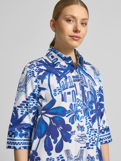 Frauenmodel trägt Relaxed Fit Klein in Knielänge mit Allover-Motiv-Print von Christian Berg Woman in Blau-Weiß aus reiner Baumwolle, Umlegekragen und Halbarm, Nahaufnahme Oberkörper.
