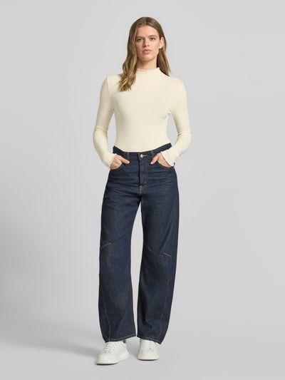 Modelka kobieca nosi Slim Fit Langarmshirt aus Lyocell-Mix von Marc O'Polo Denim, efekt: jednolity kolor, krój slim fit, wzór w paski, naszywka z logo, wyhaftowane logo, dekolt: wysokie zapięcie, rękawy: długi rękaw, zakończenie rękawów: falbanki, wykończenie: falbanki, wykończenie materiału: tkanina z mieszanka lyocellu; całopostaciowy widok z przodu.