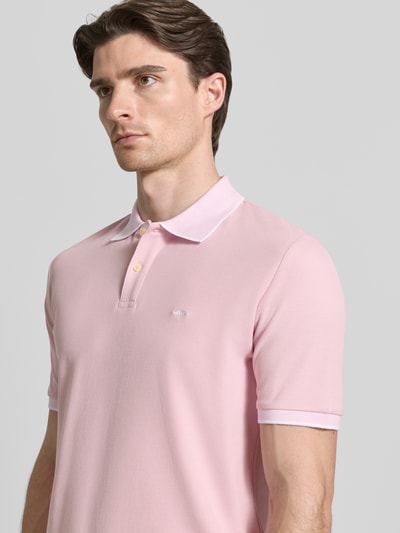 Männermodel trägt Modern Fit Poloshirt mit Stitching von Fynch-Hatton in Hellrosa, reine Baumwolle, Knopfleiste, Nahaufnahme Oberkörper.
