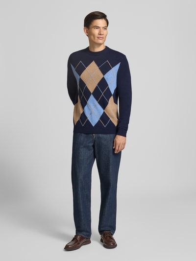 Männermodel trägt Slim Fit Pullover aus reinem Kaschmir in Strick-Optik von Christian Berg Men mit Rautenmuster, Ganzkörperansicht von vorne. Rückenlänge bei Größe M 70 cm, Ärmellänge 68 cm, Rundhalsausschnitt.