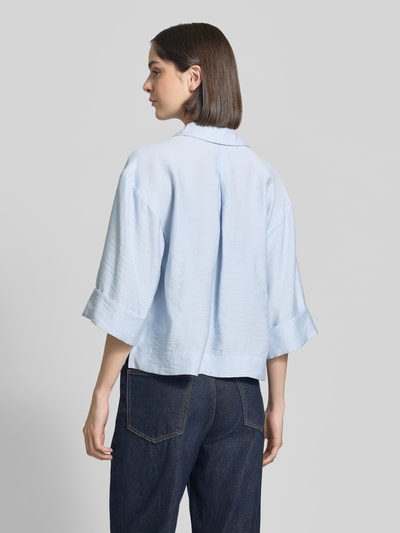 Vrouwenmodel draagt lichtblauwe dames blouse met modalmix, loose fit, platte kraag, V-hals, borstzak, omslagen mouwen, verlengde rug, model 'Felmara' van OPUS, rugaanzicht