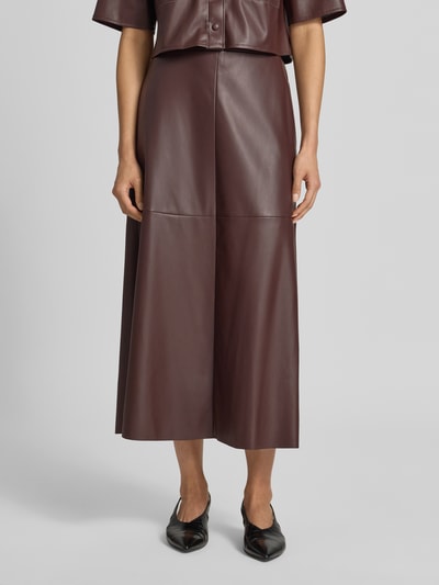 Vrouwenmodel draagt Midirok in Leder-Optik van Vera Mont, dames midirok in A-lijn met onderrok, deels elastische band, bandwijdte maat 36 37 cm, totale lengte maat 36 89 cm, kleuren donkerbruin, gladde textuur, detailopname voorkant.