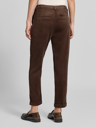 Frauenmodel trägt Cordhose mit elastischem Bund von Christian Berg Woman in Dunkelbraun, Tapered Fit, sichtbare Cordstruktur, Ganzkörperansicht Rückansicht. Material-Mix mit Stretch-Anteil, seitliche Eingrifftaschen, angedeutete Gesäßleistentaschen, Bundweite 38 cm, Innenbeinlänge 70 cm.