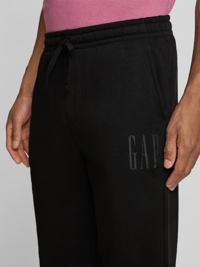 Männermodel trägt Sweatpants mit elastischem Bund und Logo van GAP, katoenmix, regular fit, logo-opdruk, detailopname voorzijde